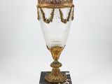 a gold and white glass vase on a marble base