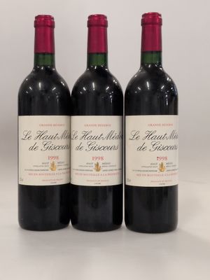 trois bouteilles de vin rouge posées sur une table blanche