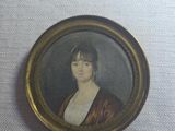 an old picture of a woman in a brown dress in a gold frame