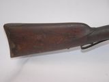 an old rifle with a wooden barrel on a white surface