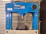 une machine bleue qui se trouve devant un mur de briques