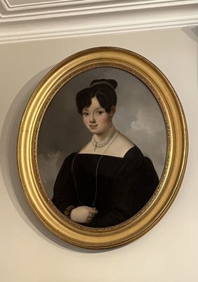 un tableau représentant une femme en robe noire, dans un cadre doré