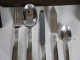 silverware on a table with a knife, spoon, and spoon rest
