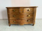 an image of a wooden chest of drawers with brass knobs