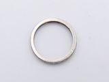 silver ring on a white surface with a small hole in the middle