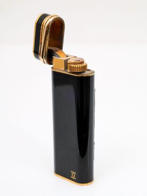 un gros plan d'un briquet posé sur une surface blanche, avec un fond blanc