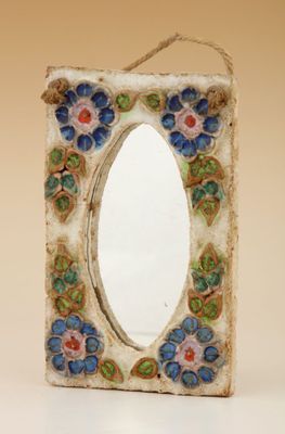 une photo d'un miroir orné de fleurs
