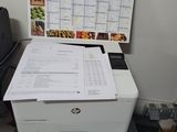 a printer sitting on top of a desk with a calendar on the wall