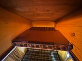 a bed in the middle of a room with a wooden floor