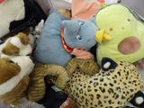 de nombreuses peluches rassemblées dans un panier posé par terre