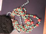 un sac à main et un collier de perles posés sur une table