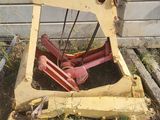 un bulldozer jaune immobilisé dans l'herbe, à côté d'un bâtiment