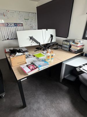 un bureau sur lequel se trouvent un écran, un clavier, une souris et d'autres éléments