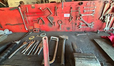 un grand nombre d'outils accrochés au mur
