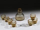 six verres et une carafe posés sur une table
