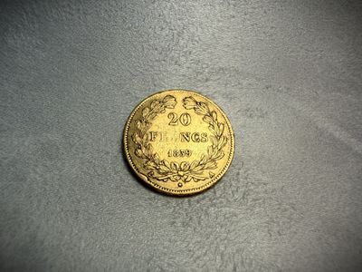 a close up of a gold coin on a gray surface