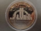 the world trade center coin is in a clear plastic container