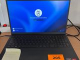 un ordinateur portable posé sur un bureau, avec une étiquette de prix dessus