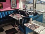 tables and booths in a restaurant with a checkered floor