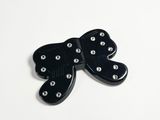 black butterfly brooch with silver studs on a white background