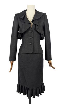 un tailleur noir et une jupe à volants sur un mannequin, un mannequin, un mannequin, un mannequin, un mannequin