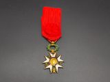 a close up of a medal on a table with a red ribbon