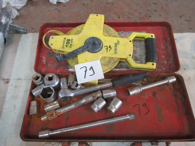 un plateau rouge posé sur une table, sur lequel se trouvent des outils