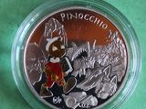a close up of a coin in a plastic container on a green surface