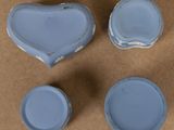 four pieces of blue pottery sitting on top of a brown surface