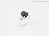 a blue sapphire and diamond ring on a white background
