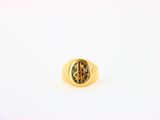 Gros plan sur une bague en or ornée d'une pierre verte