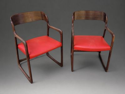 paire de chaises avec assise et accoudoirs recouverts de cuir rouge
