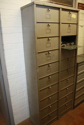 a tall cabinet with many drawers in it in a room