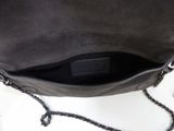 the back of a black purse with a chain hanging from it