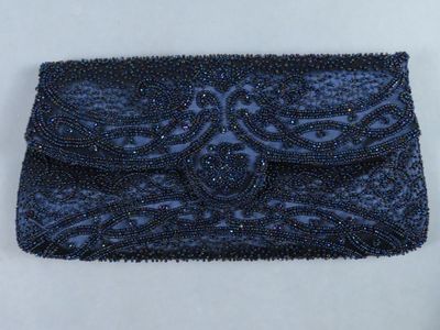 une pochette bleue ornée de perles sur fond blanc