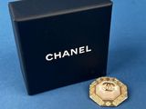 a close up of a gold and black box with a pin on it