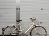 un vélo blanc garé à côté d'une porte de garage