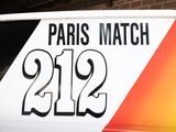 a bus with the number 21 on it parked in front of a brick building