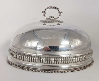 un plat ancien en argent recouvert d'une cloche en verre surmontée d'une couronne