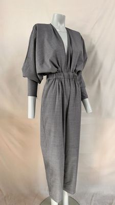 a mannequin wearing a gray dress with long sleeves and a v neckline