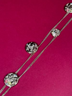 a close up of a necklace on a pink surface