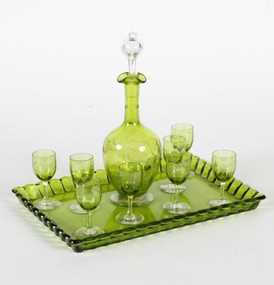 un service composé d'une carafe en verre vert et de verres à vin, présenté sur un plateau