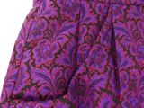 a close up of a purple and black paisley print dress