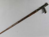 an old cane with a wooden handle sitting on top of a white surface