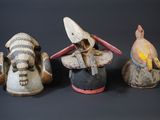three small wooden figurines of different shapes and sizes on a black surface