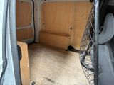 the inside of a van with a netted door and a bench in the back