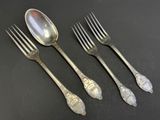 four silver spoons and a fork on a black surface