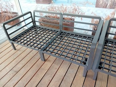 deux lits métalliques posés sur un plancher en bois