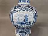 a blue and white vase with a sailboat on it