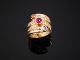 a close up of a gold ring with pink and orange stones